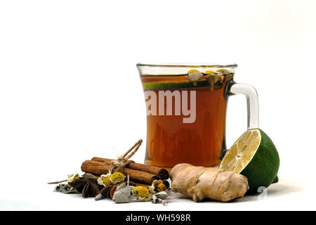 Glas Tasse Kräutermischung Tee mit Zimt, Ingwer, Salbei, Linden, Daisy, Kalk und Sternanis. Mit Kräutern, isoliert auf weiß dekoriert. Stockfoto