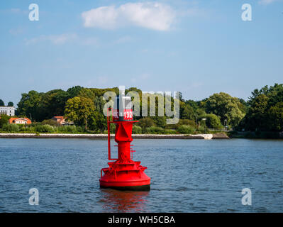 Hamburg, Deutschland - 25. August 2019: rote Boje auf der Elbe am Tag mit Wasser im verschwommenen Hintergrund. Stockfoto