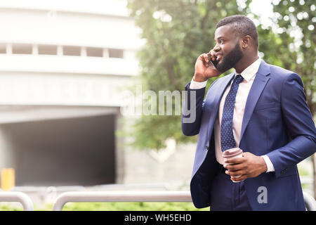 Bärtige Afrikanische amerikanische Geschäftsmann mit Mobiltelefon mit Kunde Stockfoto