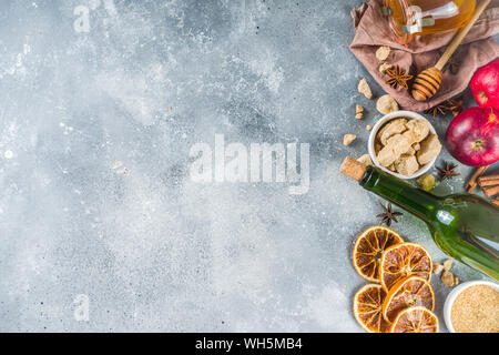 Glühwein Rezept Zutaten auf grauem Stein. Weihnachten Winter wärmende Getränke Kochen - Flasche Wein, Honig, Orange, Zimt, Anis, Muskat, Stockfoto