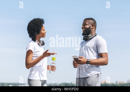 Paar sprechen über Laufen Training Plan in der Nähe des Flusses Stockfoto