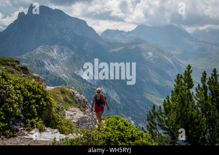 Eine Frau Wanderungen auf einem Ridge Trail in großer Höhe auf Dent du Villard in der Nähe von Courchevel in den Französischen Alpen. Stockfoto