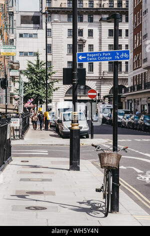 London, Großbritannien - 18 Juli 2019: Mit dem Fahrrad durch eine Laterne und Leute, die in der Entfernung auf einer Straße in Marylebone, ein schickes Wohnviertel von berühmten Londoner f Stockfoto