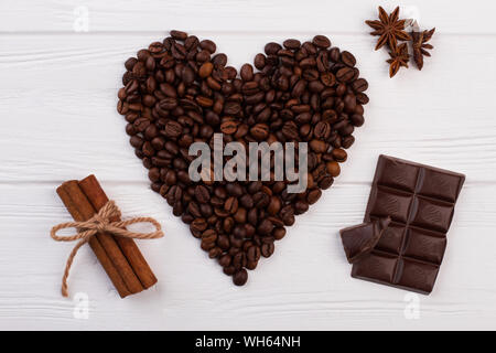 Herz aus Kaffeebohnen, Schokolade und Gewürzen. Stockfoto
