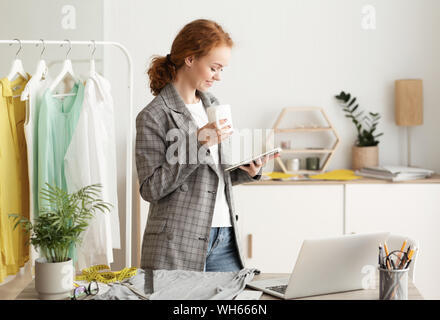 Kaffeepause. Fashion Designer Kaffee trinken und die Verwendung von Tablet Stockfoto