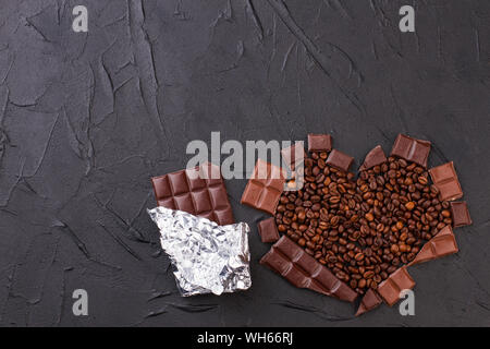 Schokoladen-Bar und Herz aus Kaffeebohnen. Stockfoto