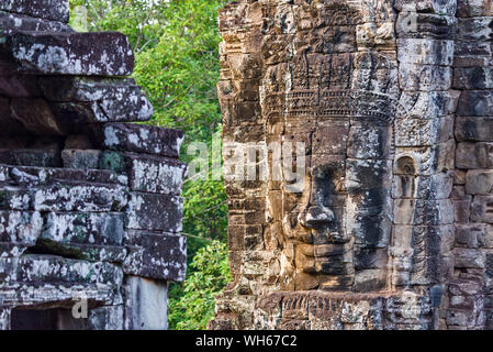 Rätselhaft und lächelnden steinernen Gesichter des Buddha Riesen an den Bayon Tempel in Siem Reap, Kambodscha Stockfoto