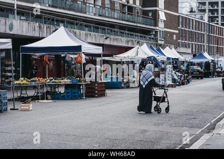 London, Großbritannien - 18 Juli 2019: Frau vorbei gehen. Stände auf der Church Street Market, London, ein prominenter Street Market mit traditioneller Atmosphäre und bietet Eve Stockfoto