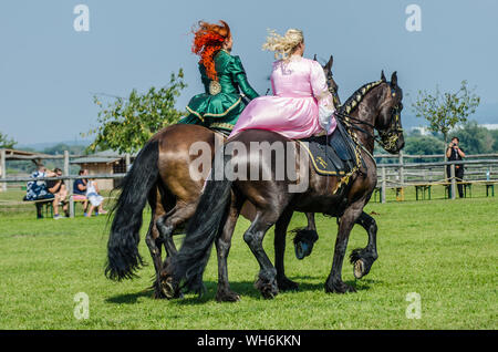 Schloss Hof Großes Pferdefest 2019 Große Equestrian Show auf Schloss Hof Schloss mit zwei Frauen reiten auf einer Seite Sattel Stockfoto