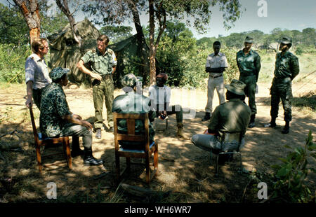 Lt Colonel Andrew Parker Bowles, auf der linken Seite, am Lager Alpha, Rhodesia-Zimbabwe 1980. Er ist gesehen, die Überwachung der Patriotischen Front Truppen aus der Buchse in der Britischen Armee laufen Holding camps in der Zambezi Tal als Teil der Lancaster House Friedensprozess nach den Rhodesian Bürgerkrieg beendet. Er war Leitender Militärischer Verbindungsoffizier zu Lord Soames, als er Gouverneur von Rhodesien während der Übergang zum Mehrheitsprinzip Zustand von Simbabwe 1979 - 1980. Er war Mitarbeiter Qualifizierte (SQ), und wurde ein Oberstleutnant vom 30. Juni 1980. AK47 AK47 Er die Queen's Commendation fo ausgezeichnet wurde Stockfoto