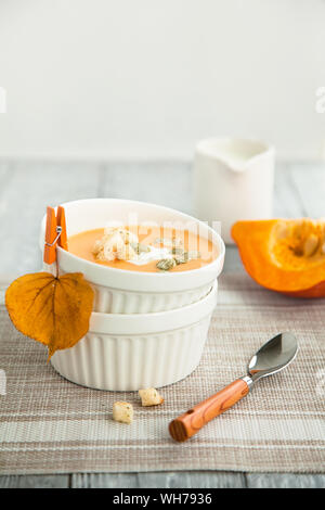 Kürbis creme Suppe in eine weiße Platte. Herbst Zusammensetzung Stockfoto