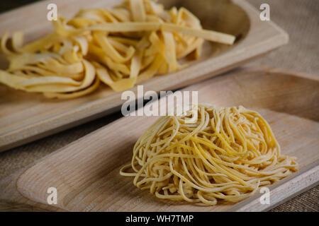 Italienische Pasta und Nudeln fettuccine auf Holz traditionelle traies (scifellette) - Italienische traditionelle Pasta mit Eiern Stockfoto