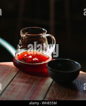 Vertikale selektive Nahaufnahme eines Klarglas Krug in der Nähe Eine kleine schwarze Schale Stockfoto