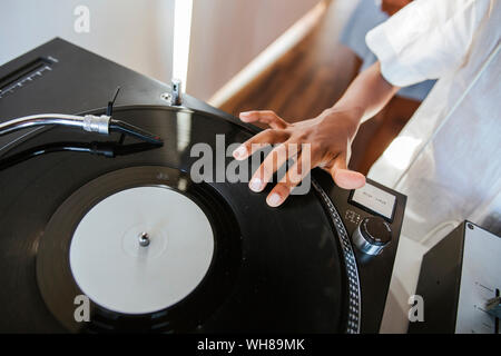 Die Hand eines jungen dj auf Schallplatte auf Drehsockel Stockfoto