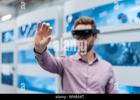 Unternehmer tragen AR-Gläser in ein modernes Werk Stockfoto