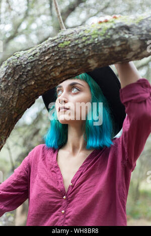 Porträt der jungen Frau mit gefärbten blaue und grüne Haare und nasenpiercing in der Natur Stockfoto