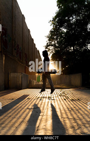 Silhouette der Skater springen in der Luft an der Hintergrundbeleuchtung Stockfoto