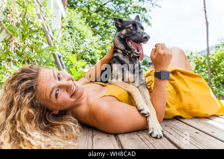 Husky Schäferhund Mischling Hund und seine Geliebte Lügen auf Holzbrett Stockfoto