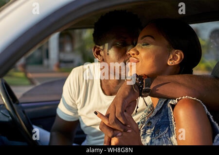 Junges Paar Auto sitzen, küssen Stockfoto