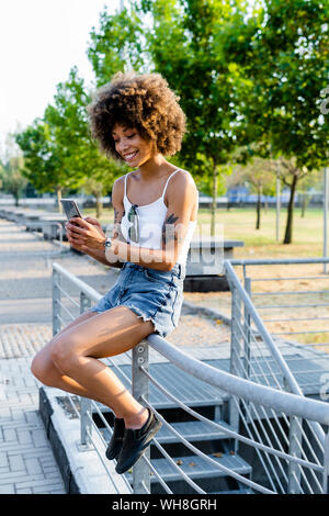 Portrait von tätowierten jungen Frau unter selfie mit Smartphone im Sommer Stockfoto