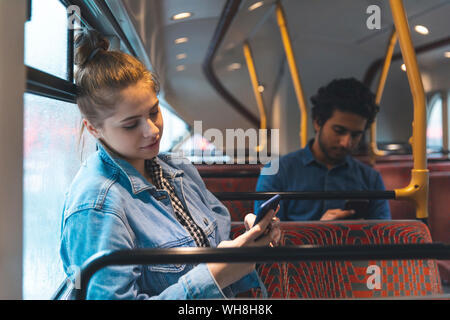 Der Mann und die Frau mit Handys im Bus Stockfoto