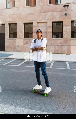 Portrait von tätowierten jungen Mann stehen auf Skateboard Stockfoto