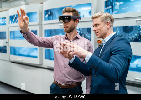 Zwei Geschäftsleute mit AR-Gläser in ein modernes Werk Stockfoto