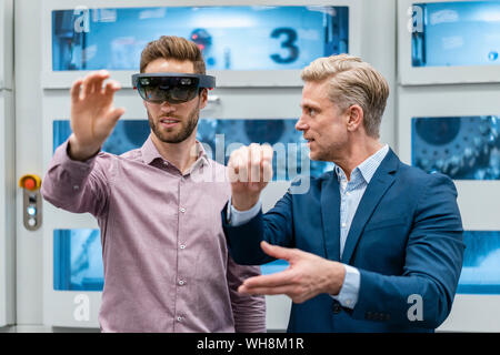 Zwei Geschäftsleute mit AR-Gläser in ein modernes Werk Stockfoto