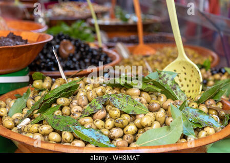 Close-up frische Oliven in Schüssel mit Holzlöffel zum Verkauf An einem Stallmarkt in der Provence Frankreich Stockfoto