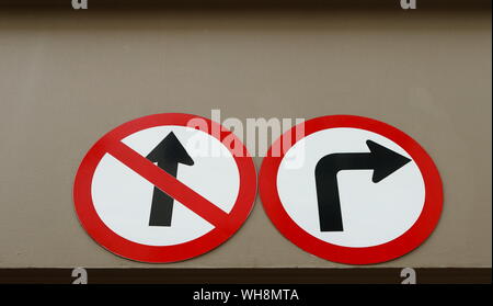 Zwei Verkehrszeichen kein Eintrag Closeup rechts und biegen Sie vor der Installation an der Wand eines Gebäudes, Low Angle View, keine Auswahl Konzept Stockfoto