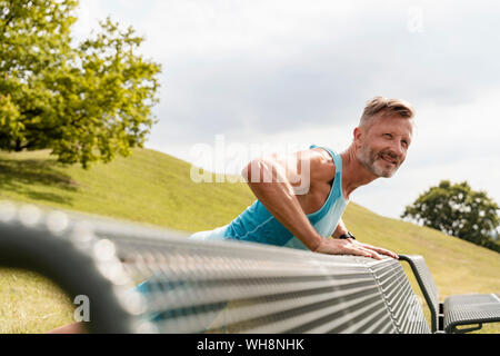 Sportliche Mann dehnen in einem Park Stockfoto