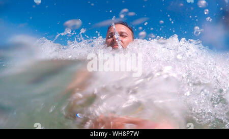 Man Schiffbruch mitten in den Wellen des Meeres, sein Gesicht ist mit Wasser besprüht Stockfoto