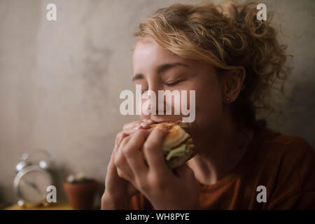 Porträt der jungen Frau essen Hamburger Stockfoto