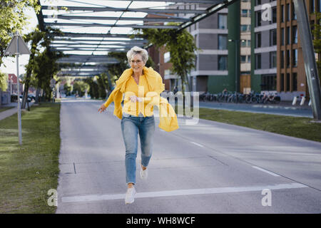 Gerne reife Frau springen in die Luft, Stockfoto