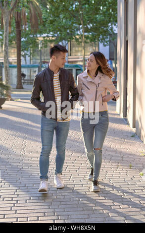 Paar Jeans und Lederjacken zu Fuß auf der Straße in den Abend Stockfoto