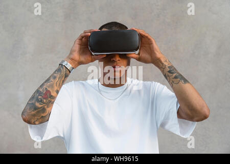 Portrait von tätowierten jungen Mann mit Virtual Reality Brillen Stockfoto