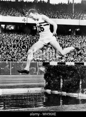 Aus., Melbourne, Olympics, 1956: Chris Brasher von Großbritannien am Wasser Sprung auf die letzte Runde der 3000m Hindernislauf.. Stockfoto
