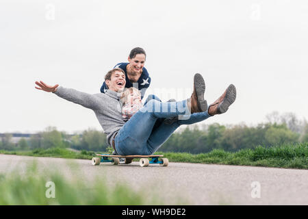 Vater und Sohn Spaß, Spielen mit Skateboard im Freien Stockfoto