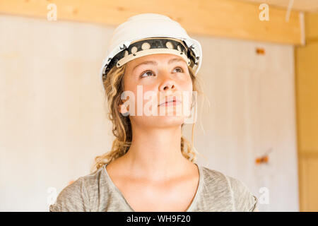 Junge Frau Kontrolle der Bau einer neuen Holzhaus Stockfoto