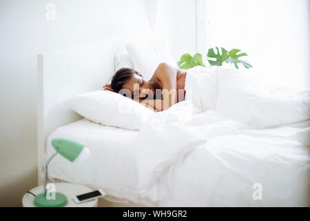 Frau schläft im Bett zu Hause Stockfoto