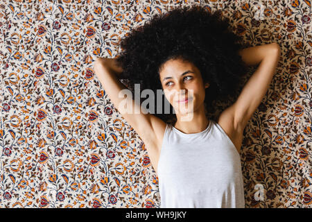 Portrait eines glücklichen jungen Frau liegend auf dem Teppich