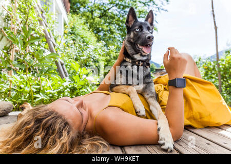 Husky Schäferhund Mischling Hund und seine Geliebte Lügen auf Holzbrett Stockfoto