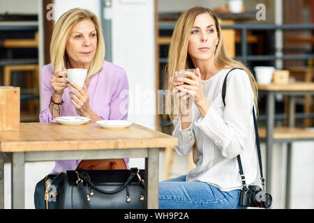 Reife Frau mit ihrer Tochter trinkt Kaffee und Tee an einem Tisch sitzen in einem Cafe Stockfoto