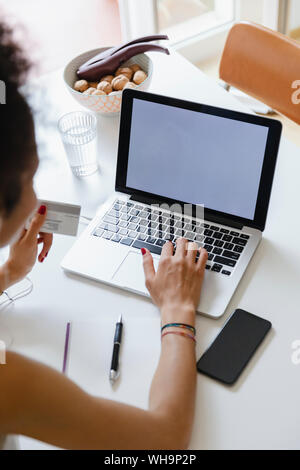 Junge Frau online Kaufen mit Kreditkarte von zu Hause aus Stockfoto
