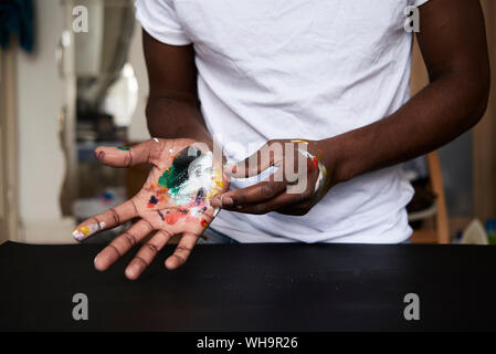 Die schmutzigen Hände der Künstler mit bunten Farben, Nahaufnahme Stockfoto