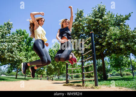 Athletische Frau und ihre Tochter zusammen springen in einem Park Stockfoto