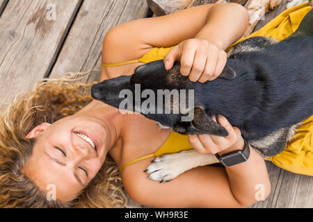 Husky Schäferhund Mischling Hund und seine Geliebte Lügen auf Holzbrett Stockfoto