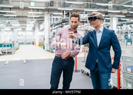 Zwei Geschäftsleute mit AR-Gläser in ein modernes Werk Stockfoto