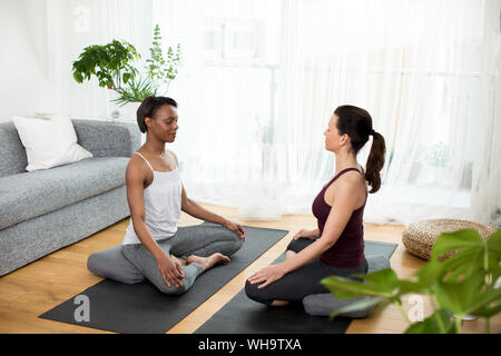 Zwei Frauen, die Yoga zu Hause Stockfoto