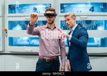 Zwei Geschäftsleute mit AR-Gläser in ein modernes Werk Stockfoto